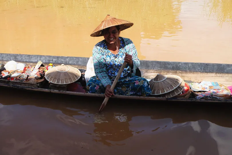 Eine Frau verkauft Souvenirs auf einem Boot am Inle See