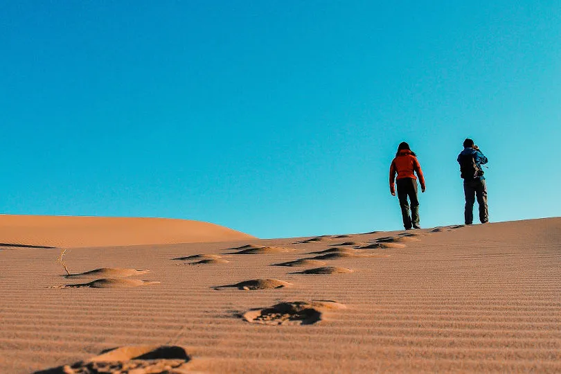 Zwei Personen wandern durch die Wüste Gobi in der Mongolei