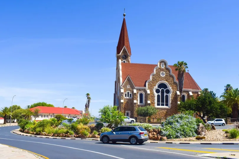 Ein Auto fährt an einer Kirche in Windhoek vorbei.